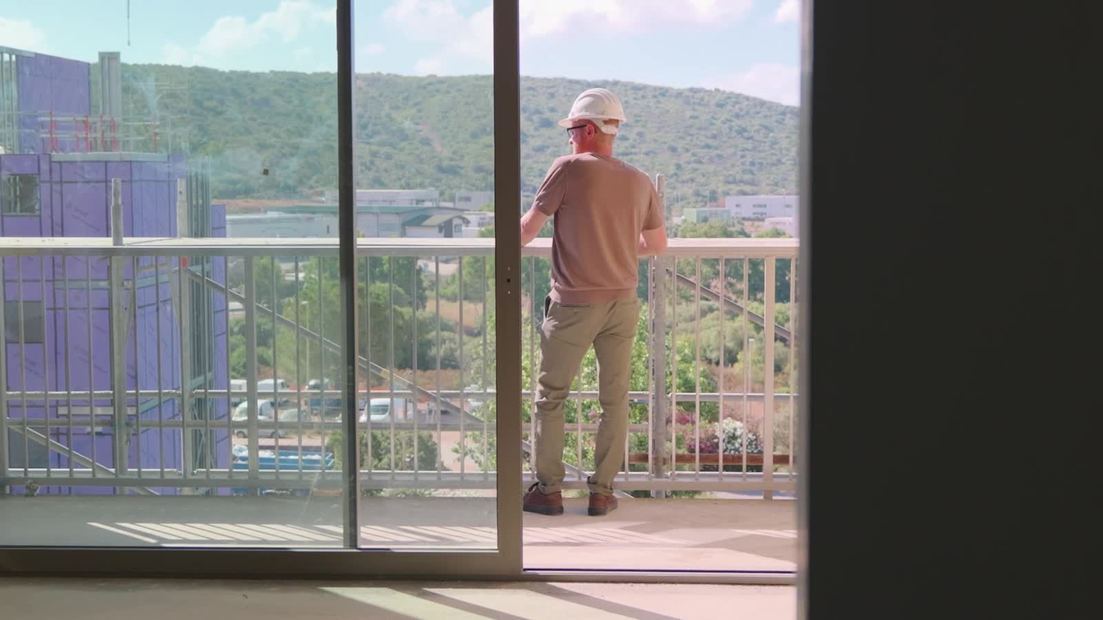 Operaio affacciato dalla loggia sul paesaggio