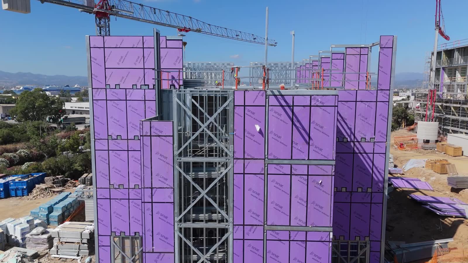 L'edificio in costruzione con la gru, rivestimento di protezione a vista
